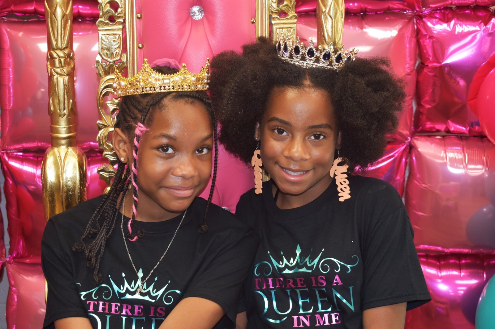 Two girls wearing crowns and There Is a Queen in Me shirts at an Enough Period gathering